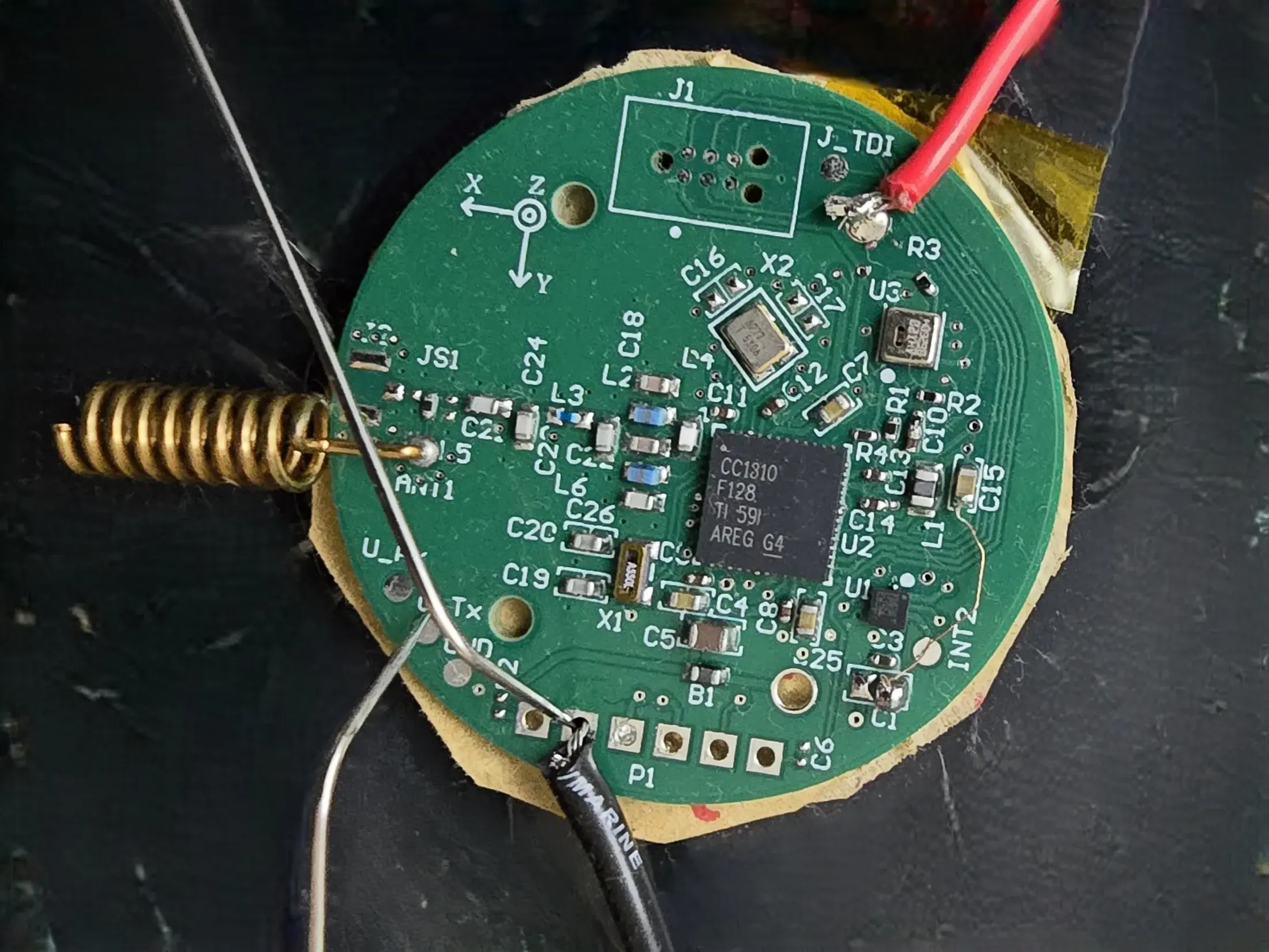Close-up of the custom CC1310 sensor PCB with temporary test wiring and a helical antenna.
