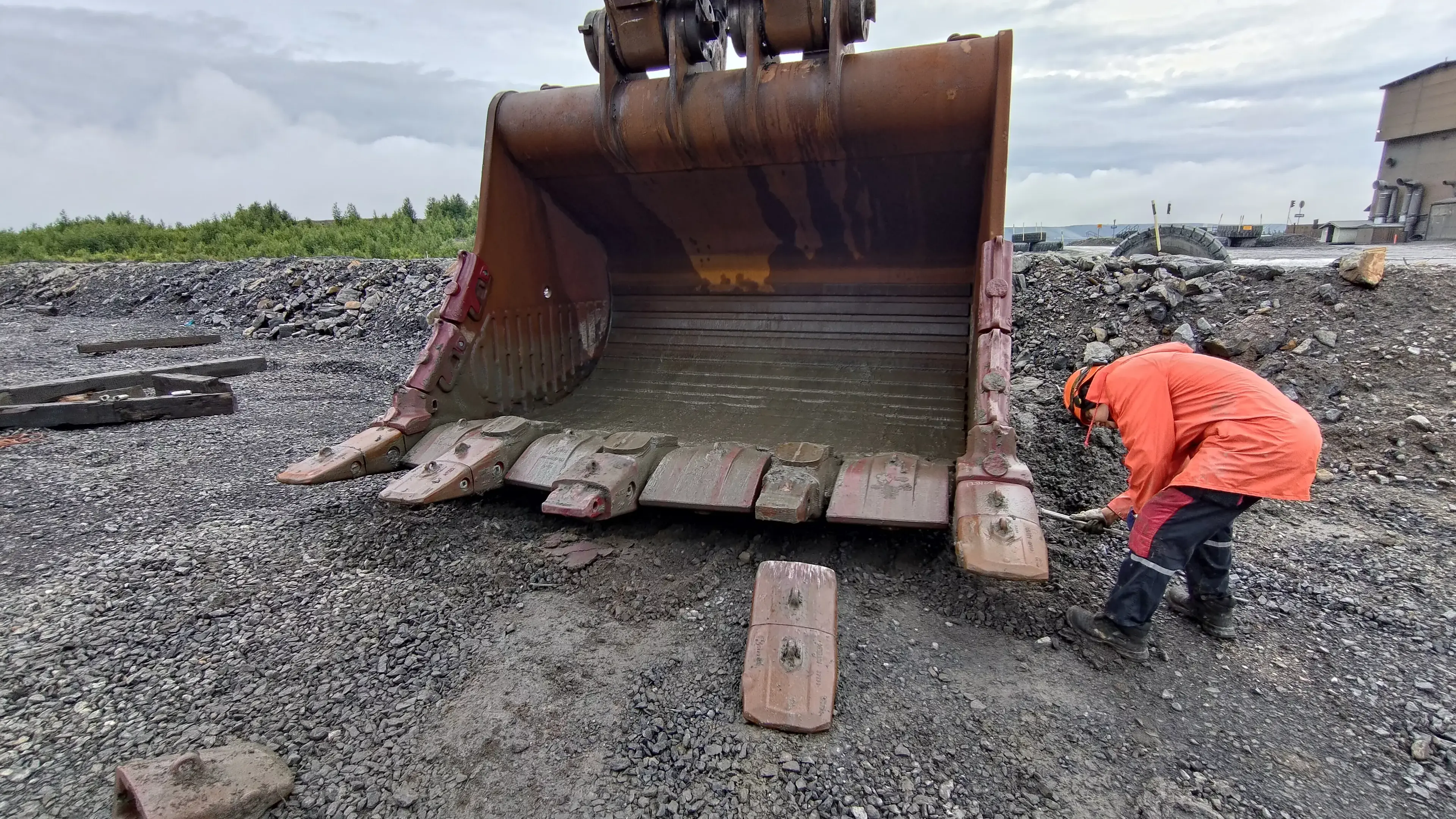 Large mining excavator at an open-pit mine in Zambia with field personnel nearby.