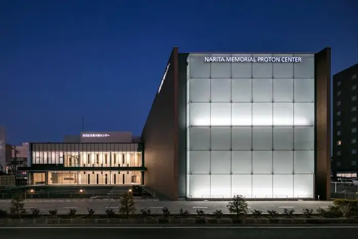 Exterior of Narita Memorial Proton Center in Toyohashi at night.