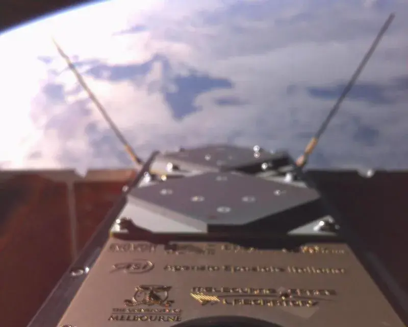 SpIRIT spacecraft hardware photographed with Earth visible in the background.